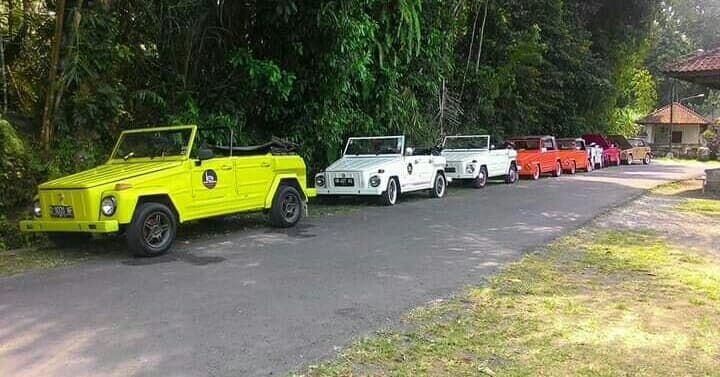 A family portrait in front of the car at Tanah Lot at low tide.